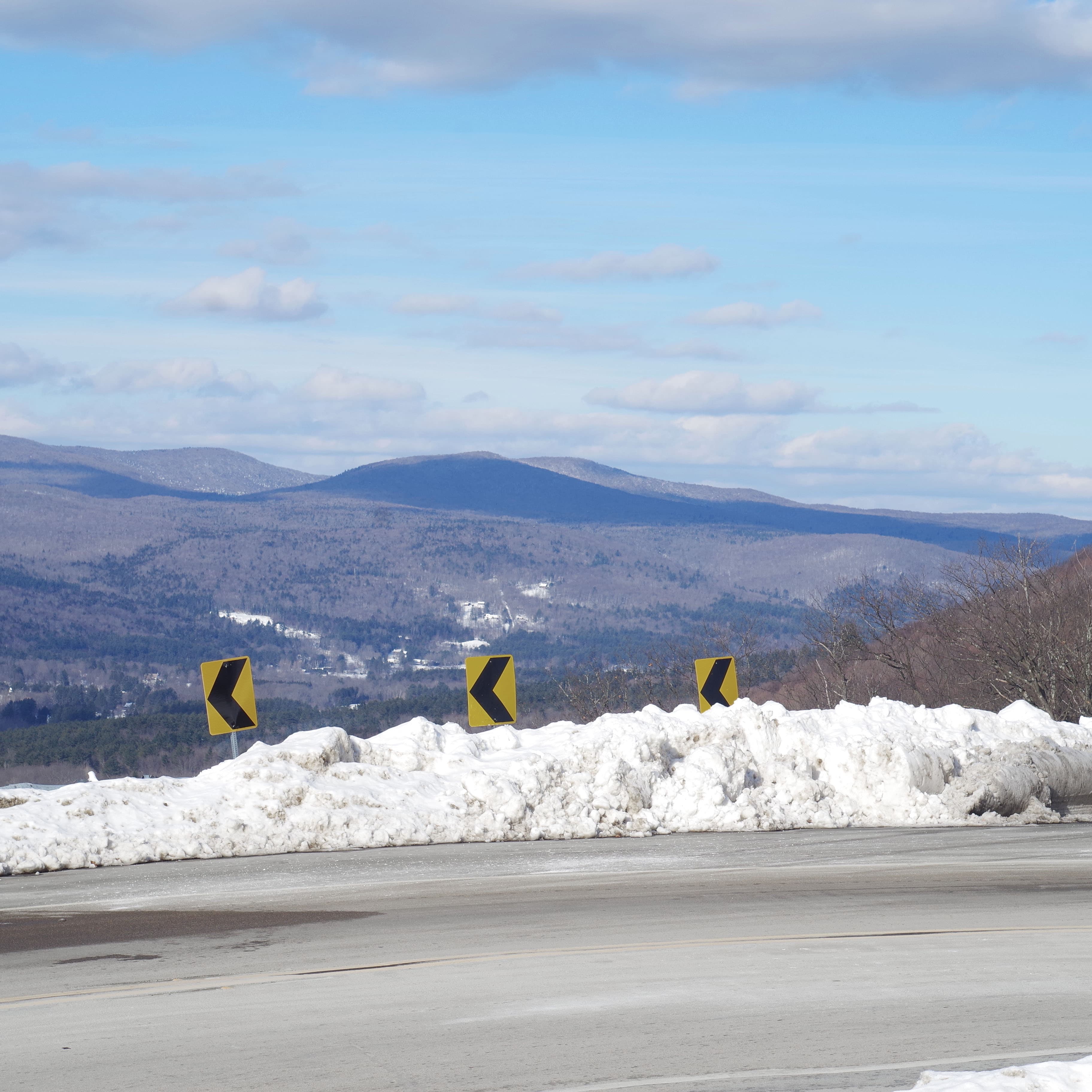 a view over a tight curve on a mountain road, looking over a valley