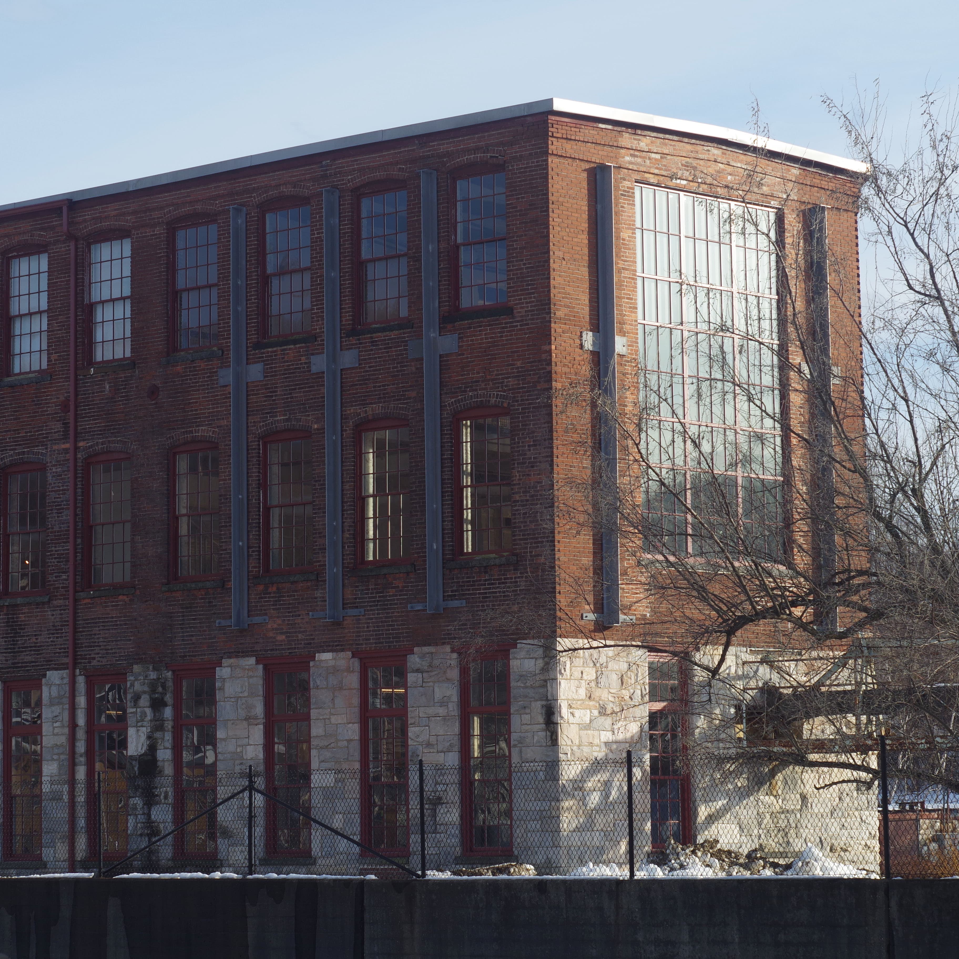 a large, long, brick building with its short side facing the sun and its long side in shadow