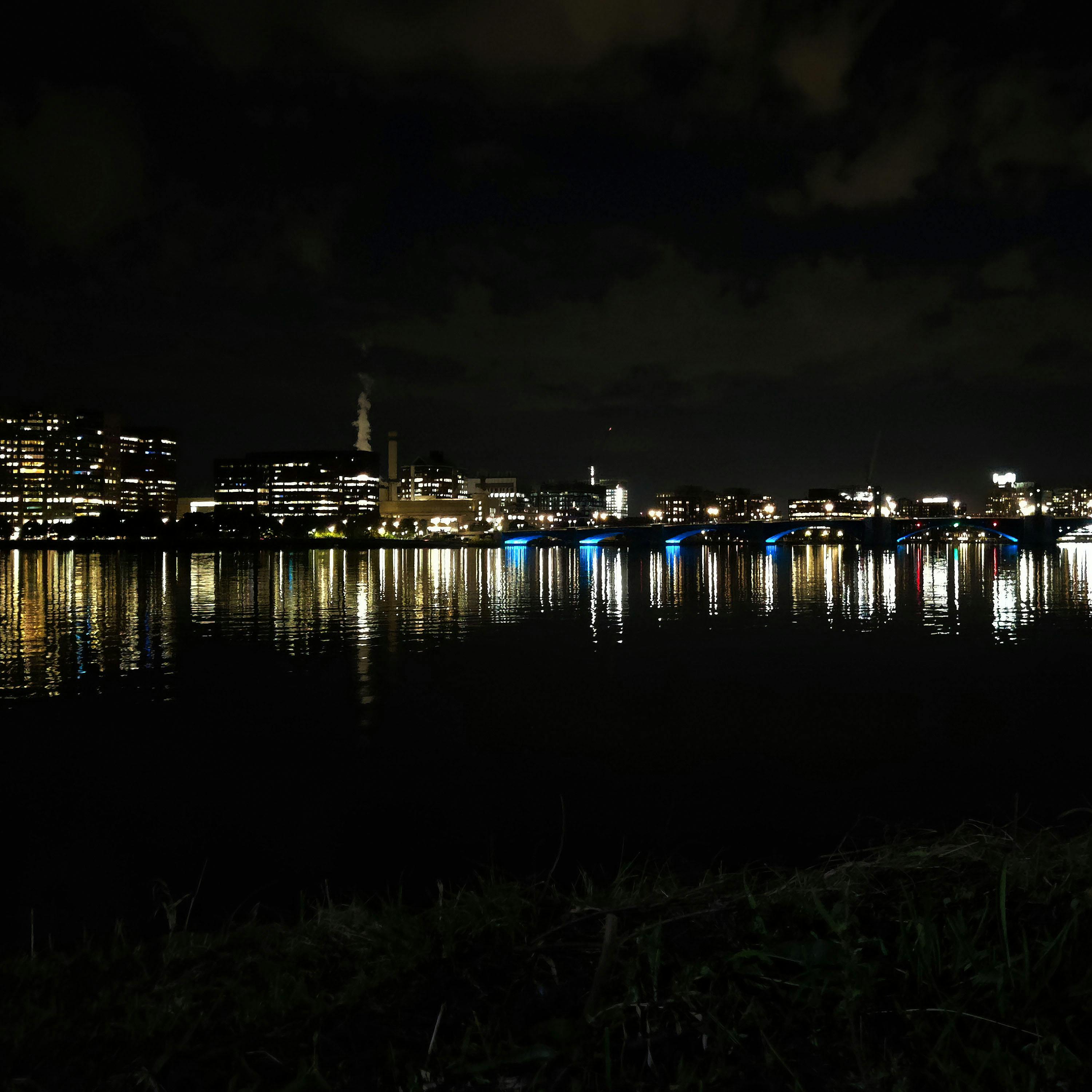 the cambridge skyline reflected over the charles river at night