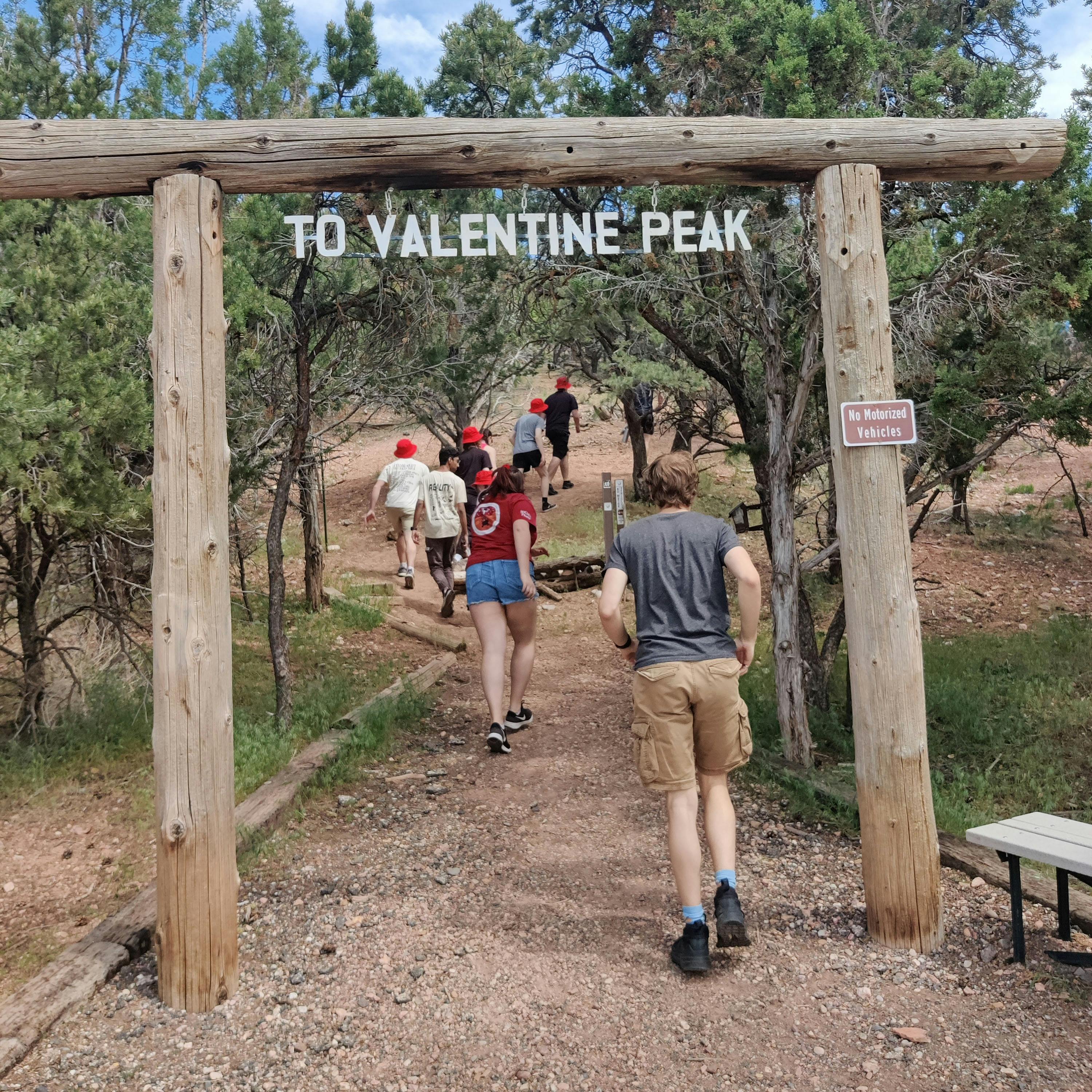 the entrance to the valentine peak trail, with the rover team walking up it